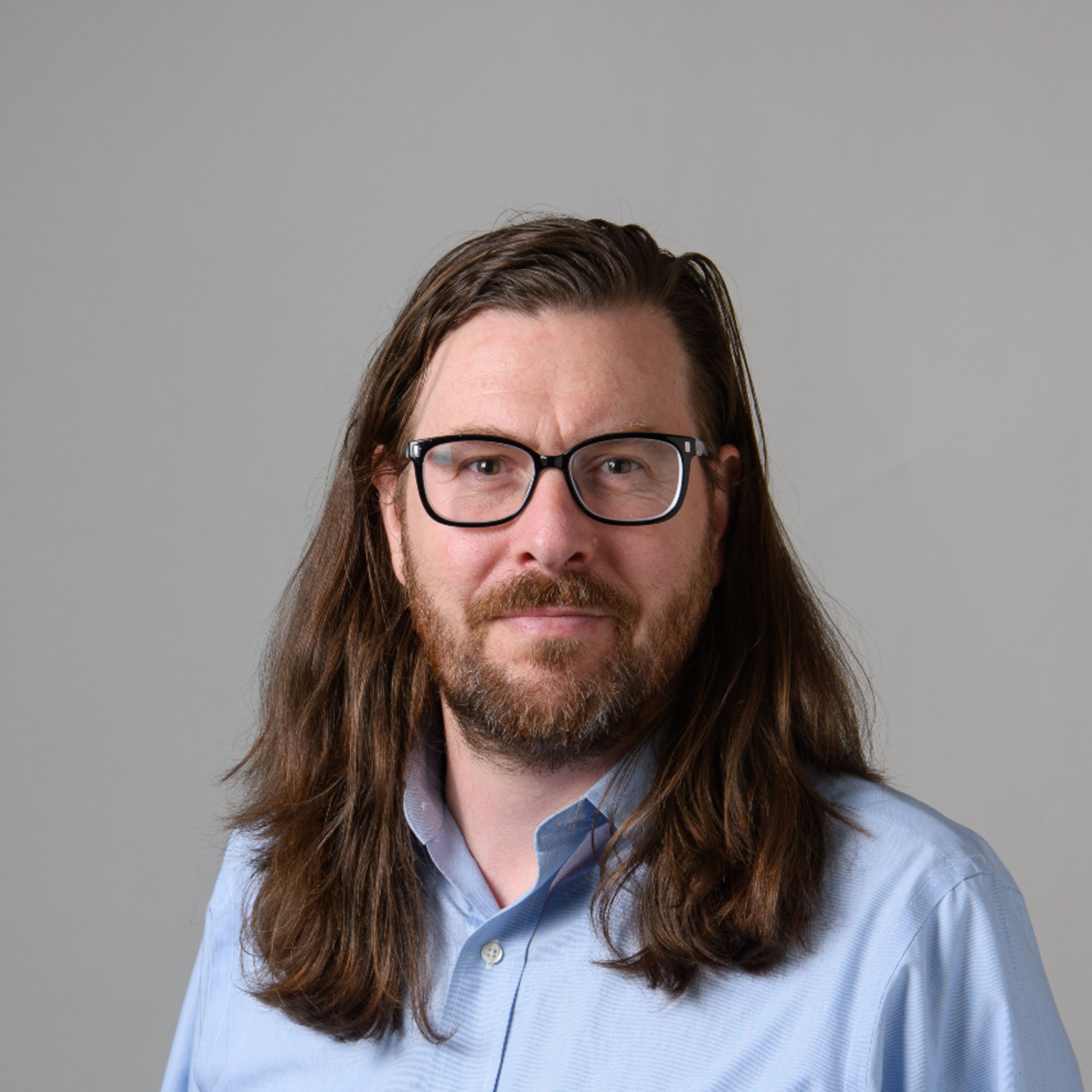 headshot of Bo wearing professional attire with a neutral background 